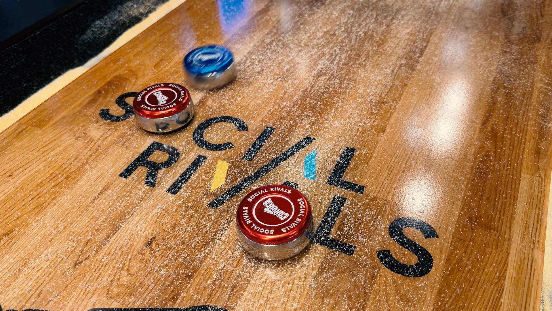 Social Rivals shuffleboard with branded red and blue pucks